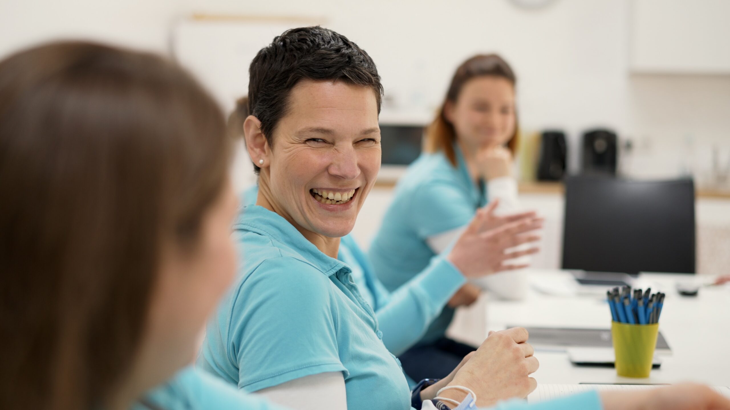 Imagefilm_Fee_1 Herzlich lachende Logopädin schaut ihre Kollegin an